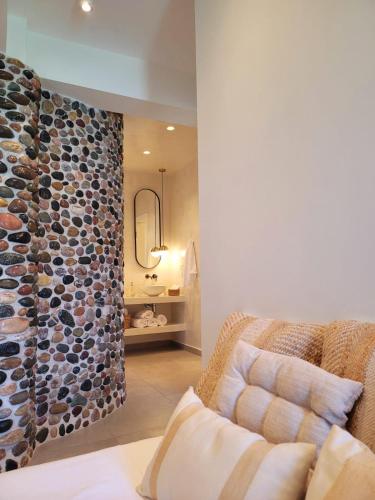 a living room with a couch and a stone wall at Artis Blue Relax in Himare