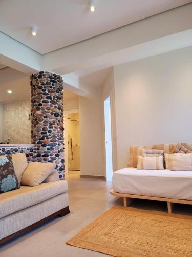 a bedroom with a bed and a stone wall at Artis Blue Relax in Himare