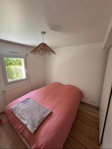 - une chambre avec un grand lit rose et une fenêtre dans l'établissement Superbe appartement vannetais, à Vannes