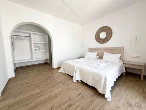 a bedroom with two beds and a mirror on the wall at Cyclades Blue in Ornos