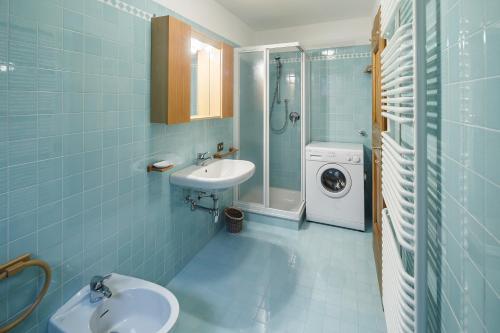 a bathroom with a sink and a washing machine at Villa Lacedel - Stayincortina in Cortina dʼAmpezzo