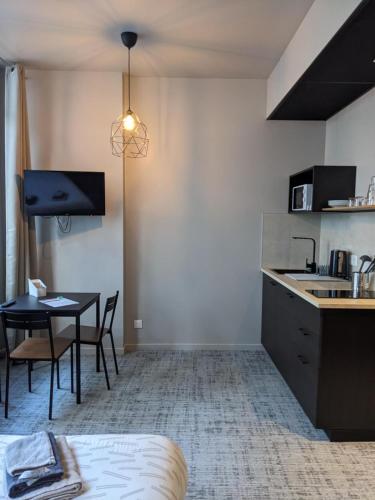 une cuisine et une salle à manger avec une table dans une pièce dans l'établissement Le 12 wifi cosy parking 3, à Saint-Étienne