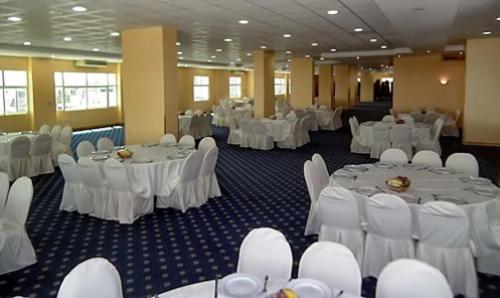 アル・ブライミにあるAl Massa Hotelの白いテーブルと白い椅子が備わる宴会場