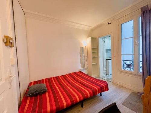 - un lit rouge dans une chambre avec fenêtre dans l'établissement Studio Paris 15e D - Tour Eiffel Roland Garros, à Paris