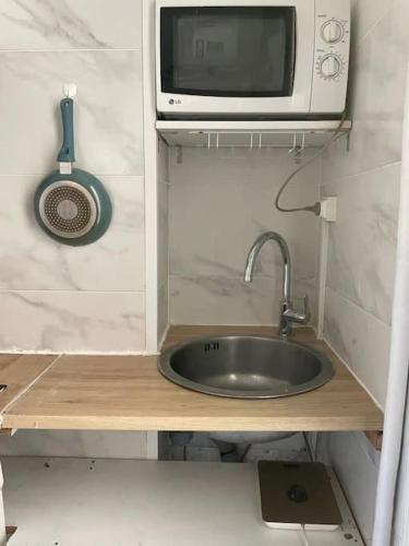 une cuisine avec un évier et un micro-ondes dans l'établissement Studio Paris 15e D - Tour Eiffel Roland Garros, à Paris