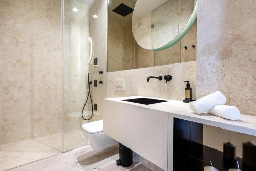 een badkamer met een wastafel, een toilet en een spiegel bij Cascais Deluxe by Homing in Cascais