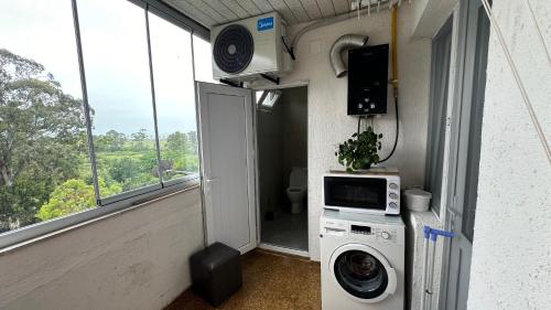 a small room with a washing machine and a window at Tatas Place in Batumi