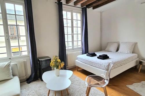 une chambre avec un lit, une table et un canapé dans l'établissement Chez Maëlle - Tour Eiffel Cosy Flat, à Paris