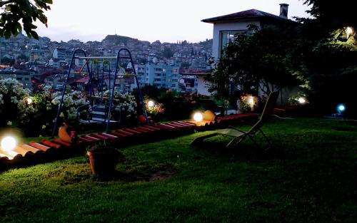 ein Park mit einer Bank im Gras in der Nacht in der Unterkunft Guest House Sofia in Sandanski