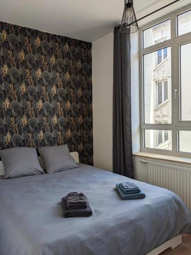 a bedroom with a bed with two towels on it at Le 12 T2 cosy wifi parking gratuit st Victor in Saint-Étienne