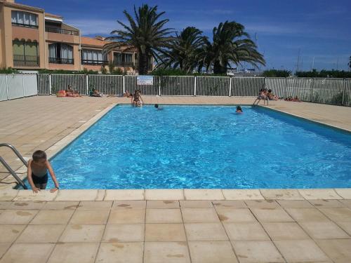 un groupe de personnes dans une piscine dans l'établissement Appartement sur marina Saint CYPRIEN plage - finalisez vos reservations sur PC pas telephone, à Saint Cyprien Plage