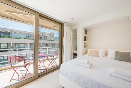 a bedroom with a bed and a balcony with chairs at A Room with a View in Athens