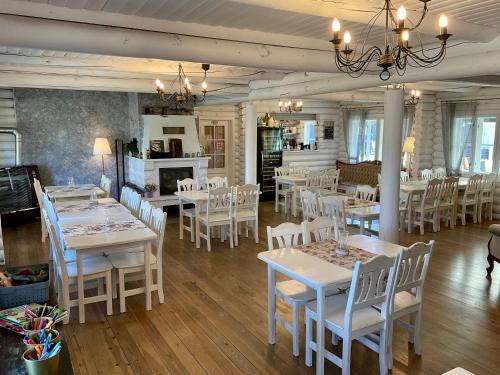 une salle à manger avec des tables et des chaises blanches dans l'établissement Kliff Butiik Majutus & Restoran, à Panga