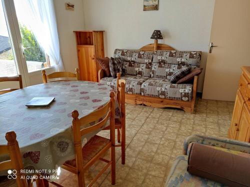 un salon avec une table et un canapé dans l'établissement Appartement Confortable 3 Pièces, Jardin, Exposé Sud, 6 Pers, Parking – Font-Romeu - FR-1-580-23, à Font-Romeu-Odeillo-Via