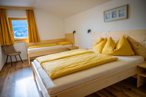 sypialnia z dużym łóżkiem z żółtą pościelą w obiekcie Residence Montana w mieście Resia