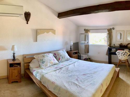 une chambre avec un grand lit et un bureau dans l'établissement Maison soignée avec grand jardin et terrasse - Le Lavandou - FR-1-308-159, au Lavandou