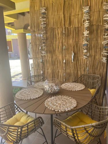 a wooden table with chairs and a table with bowls on it at Къмпинг градина луксозен апартамент in Chernomorets