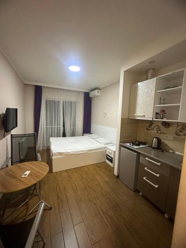 a small apartment with a bed and a table at Levanis in Batumi
