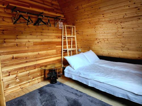 sypialnia z łóżkiem w drewnianym pokoju w obiekcie Cabana Lupul din Apuseni w mieście Mătişeşti