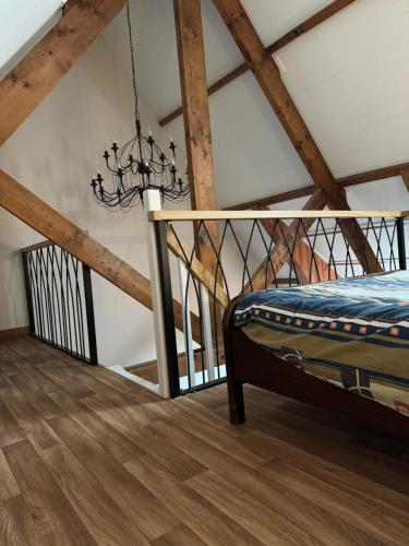 a chandelier in a room with wooden beams at Vino Grando 't Klooster in Odiliapeel