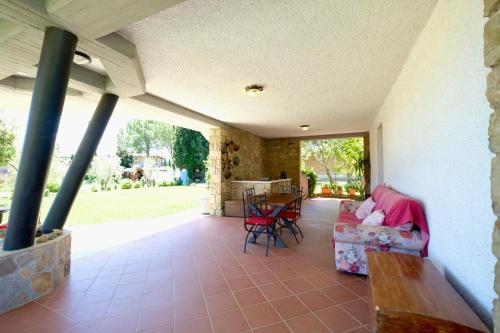 a porch with a couch and a table and chairs at Il Melograno - San Quirico d'Orcia in San Quirico dʼOrcia