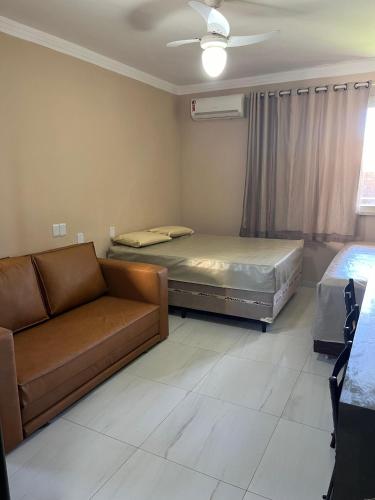 a living room with two beds and a couch at Flat Ilhéus - Jubiabá Olivença in Ilhéus
