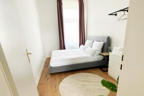 a small bedroom with a bed and a window at Modernes City-Apartment in Mönchengladbach in Mönchengladbach