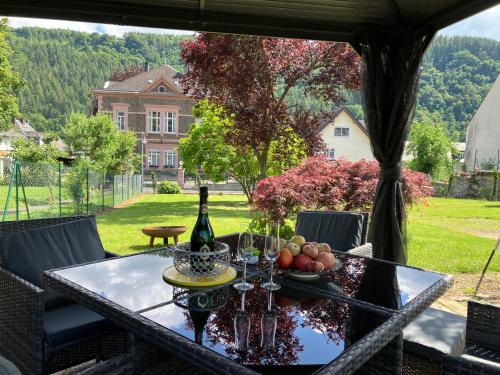 un tavolo di vetro con una bottiglia di vino e frutta di NEU - Ferienwohnungen im Winzergarten a Traben-Trarbach