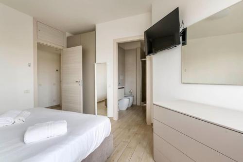 a bedroom with a white bed with a flat screen tv at Brand new 3 bedrooms apartment in Navigli area in Milan