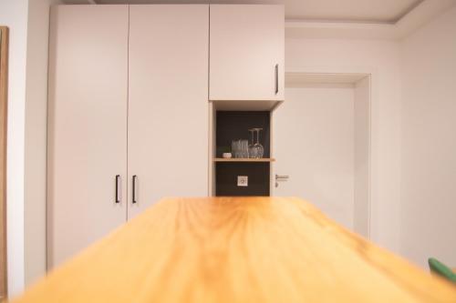 a kitchen with white cabinets and a wooden counter top at Engelns-Inn in Hövelhof