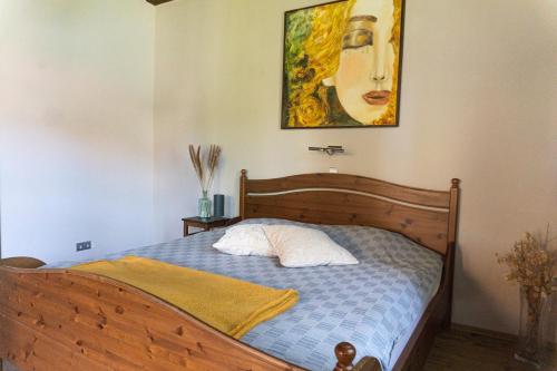 um quarto com uma cama e um quadro na parede em Rusztikus Nyaralóház em Szigliget