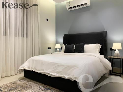 um quarto com uma cama grande e uma cabeceira preta em Kease Tawun A5-2 Royal touch Terrace XZ48 em Riyadh