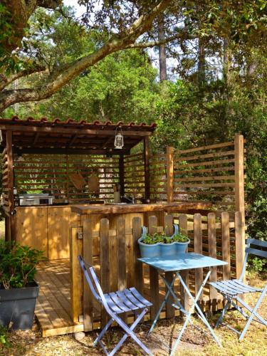 a patio with a table and chairs and a wooden fence at Domaine Authentique de Rose in Porto-Vecchio