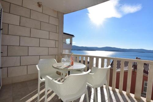 a table and chairs on a balcony with a view of the water at Holiday Home in Komarna