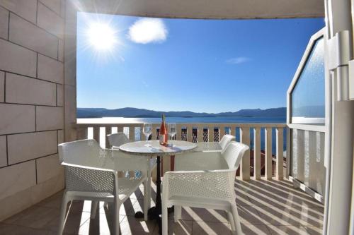 a table and chairs on a balcony with a view of the ocean at Holiday Home in Komarna
