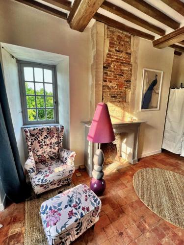 un salon avec une chaise et une lampe dans l'établissement Château en Normandie, à Planquery