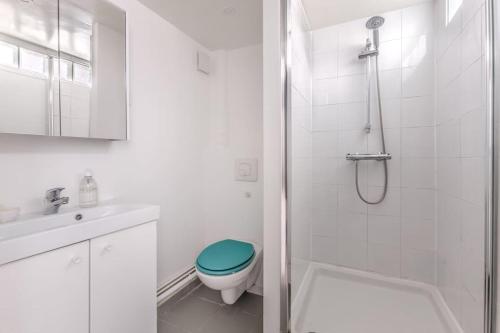 une salle de bain blanche avec toilettes et douche dans l'établissement Loft lumineux authentique, à Paris