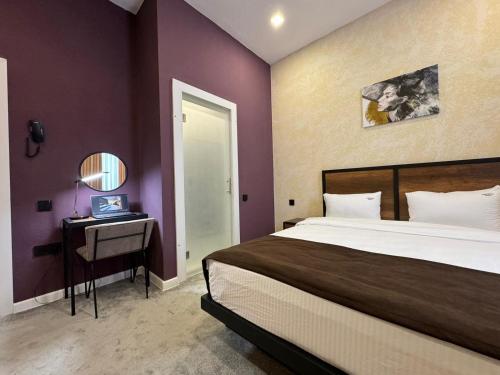 a bedroom with a bed and a table with a mirror at Liberta Hotel Baku in Baku