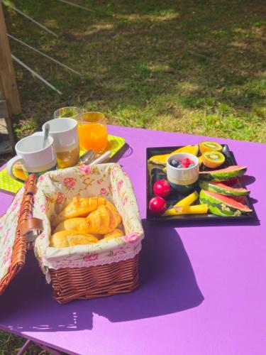 a picnic table with a basket of food and fruit at Domaine Authentique de Rose in Porto-Vecchio