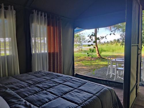 1 dormitorio con cama y vistas a una mesa en Harmony Haven Eco Camp, Udawalawa, en Udawalawe