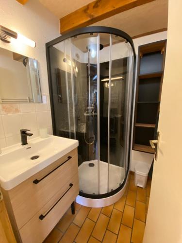 La salle de bains est pourvue d'une douche et d'un lavabo blanc. dans l'établissement Chalet tout confort au bord du gave, à Cauterets