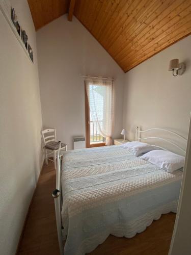 une chambre avec un grand lit avec un plafond en bois dans l'établissement Chalet tout confort au bord du gave, à Cauterets