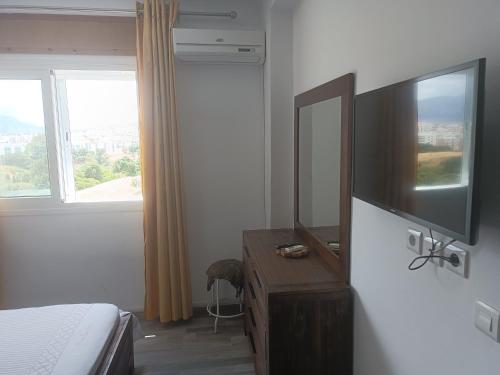a bedroom with a bed and a dresser with a television at The Oxygen 7 in Tetouan