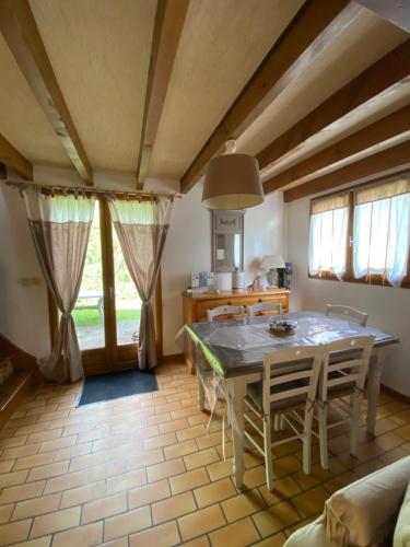 une salle à manger avec une table, des chaises et des fenêtres dans l'établissement Chalet tout confort au bord du gave, à Cauterets
