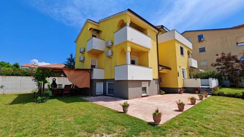 un edificio blanco y amarillo con patio en Villa Antonia en Medulin