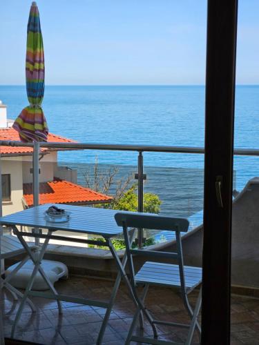 a table and chairs on a balcony with the ocean at INESA in Tsarevo