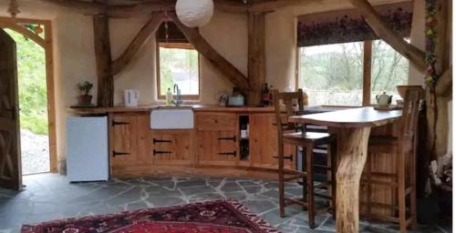 a kitchen with a white refrigerator and a table at Tara vegetarian retreat guesthouse in Carmarthen