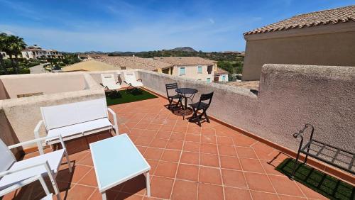 a patio with chairs and tables on a balcony at Appartamento Le Vele in Porto San Paolo