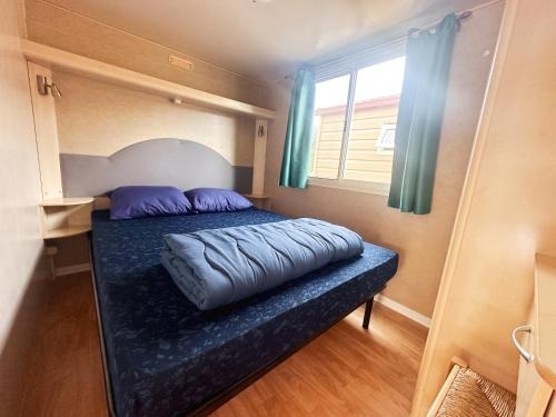 ein Bett mit lila Kissen in einem kleinen Zimmer in der Unterkunft TuscanyChalets - luxe family chalet near sea with pool in Viareggio