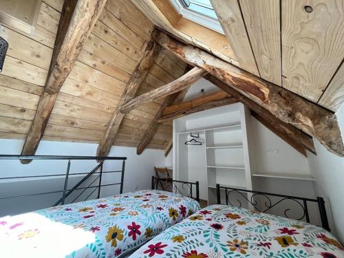 une chambre avec un lit et un plafond en bois dans l'établissement Gîte du Tilleul - Sauna & Jardin, à Olby